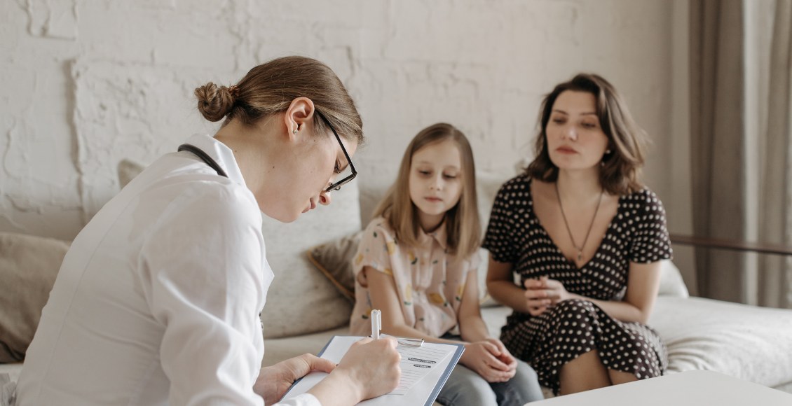 امرأة وطفلتها في عيادة طبيبة تجري اختبار للتحقق من صحة معلومة التشخيص الخاطىء لاضطراب فرط الحركة