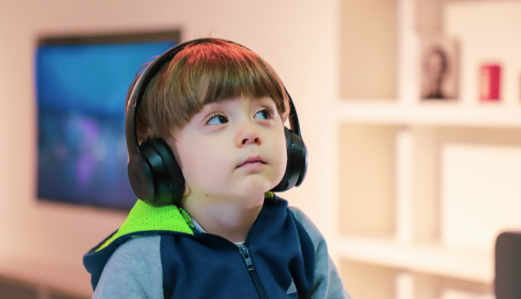 طفل صغير يستمع إلى الموسيقا حيث يعاني من صعوبات اضطراب طيف التوحد الشديد
