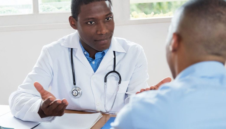 طبيب ذو بشرة سمراء يوضح لمريضه علل التشخيص المزدوج