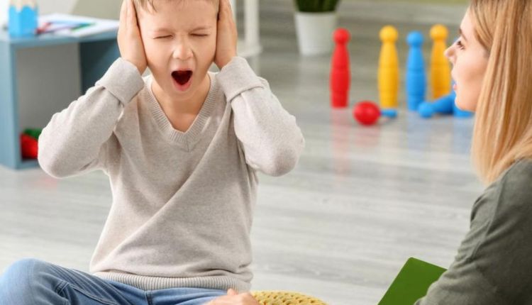 طفل يغطي أذنيه ويصرخ وهي من علامات التوحد وكذلك فرط النشاط للإشارة لوجود اضطرابات أخرى بأعراض تشبه التوحد