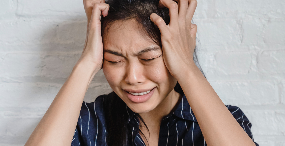 فتاة تضع يديها على رأسها تظهر عليها بعض أعراض أنواع القلق المختلفة - different types of anxiety
