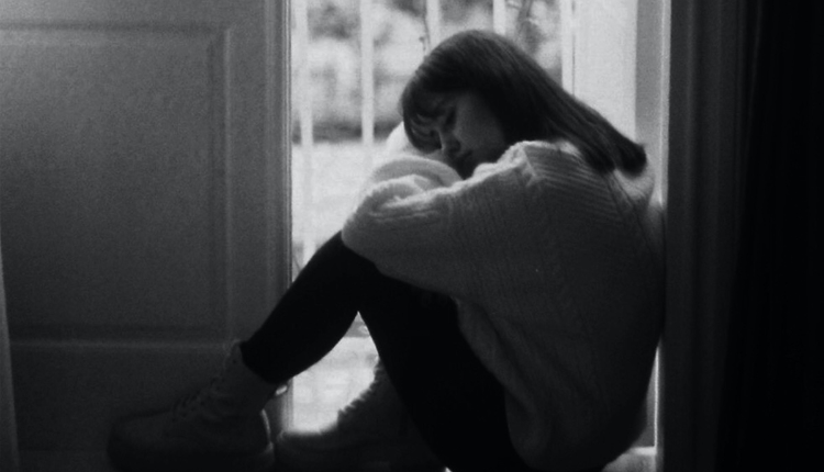 فتاة تجلس وحيدة تسند رأسها على ركبتيها من أنواع الشخصيات المختلفة الانطوائية تعاني التوتر والقلق